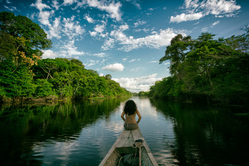 A woman rides in the bow of a traditional boat along the Peruvian Amazon.