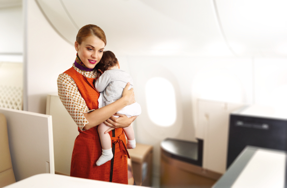 A Flying Nanny comforts a baby aboard an Etihad Airways plane