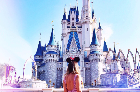 A female stands in front of Cinderella's Castle at Walt Disney World in Orlando, Florida