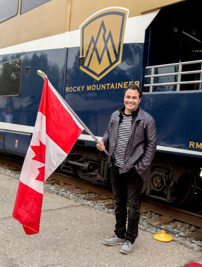 TV chef Miguel Maestre waves the Canadian flag outside the Rocky Mountaineer train carriage