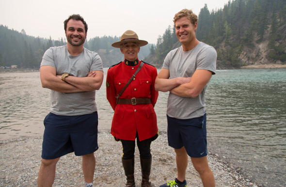 TV hosts Chris Brown and Miguel Maestre pose with a Canadian Mountie outdoors in Canada