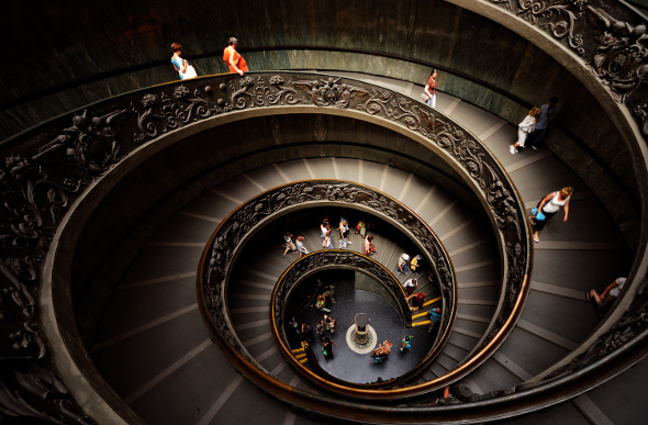 People wander down a spiral staircase in the Vatican Museum in Vatican City