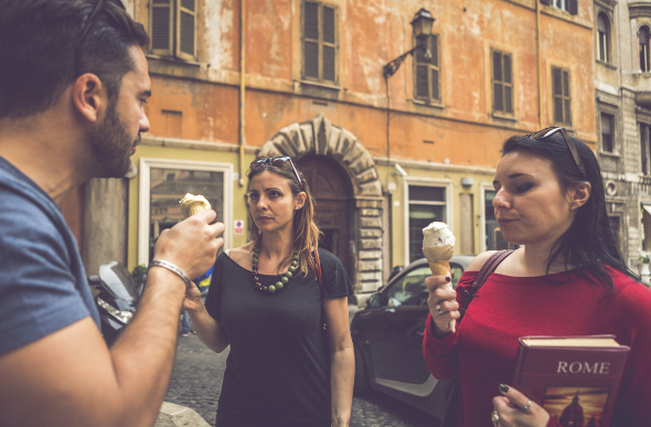 Three young tourists sample different gelato flavours in a Rome street