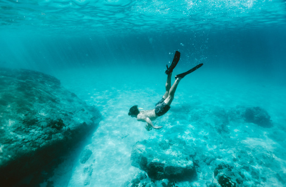 A man snorkels underwater in the Similian Islands, an archipelago in Phang Nga, Thailand