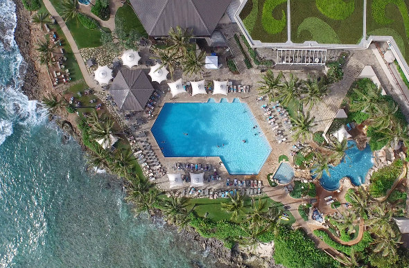 An aerial shot of the ground of Turtle Bay Resort on the North Shore of Oahu shows the pool areas and the ocean