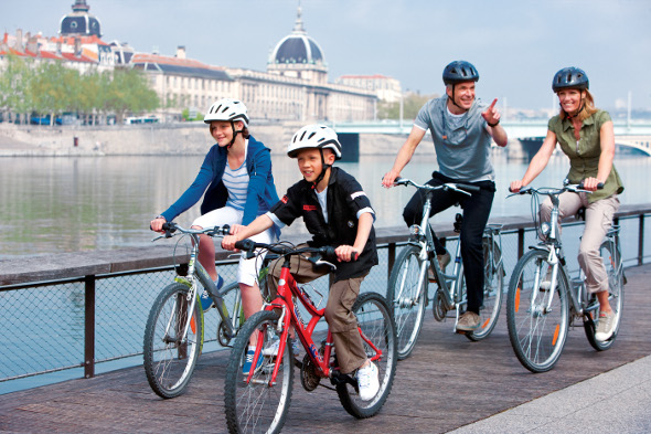 Family cycling along Danube river in Budapest