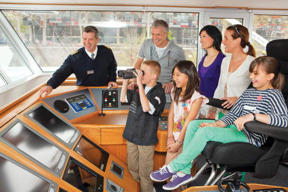 Family on bridge on river cruise with captain