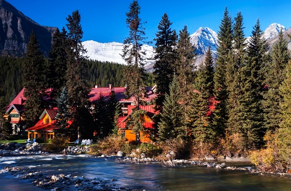 Orange and red mountain lodge surrounded by trees.