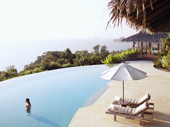 A woman stands in the infinity pool of the Hilltop Reserve, a three-bedroom private pool villa overlooking Phang Nga Bay at Six Senses Hideaway Yao Noi. Thailand.