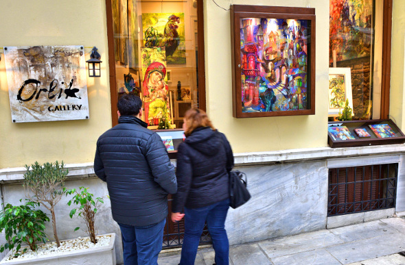 Two people looking at artwork on the street