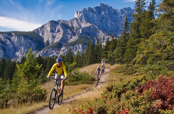 A family cycling through nature in Banff.