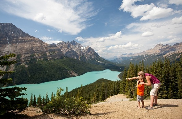 Small boy taking a photo with his mum of a picturesque view in Banff.