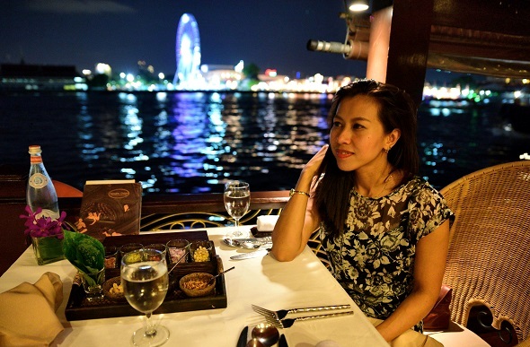 A woman enjoying Thai food on the Anantara cruise.