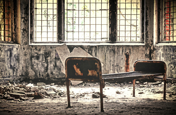 Rusted bed frame in abandoned hospital