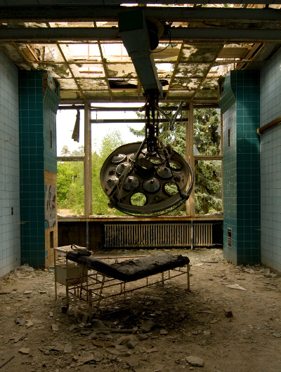 Ruined operating room and equipment in abandoned hospital