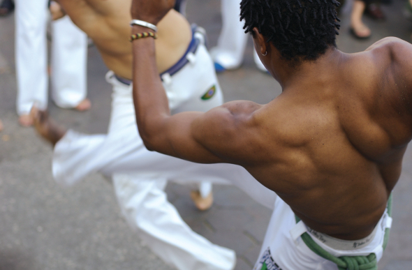 Two muscle-clad Brazilians performing capoeira