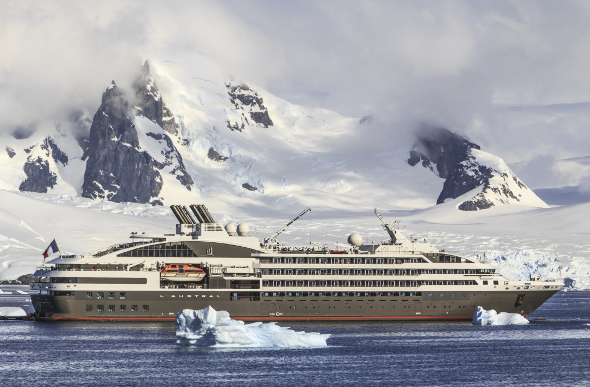 A cruise ship floating past icy mountains in Alaska