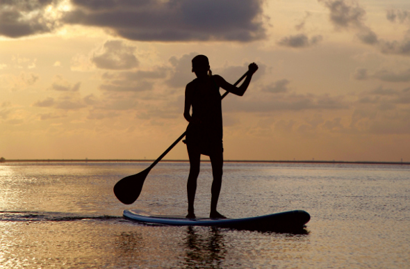 Stand-up paddle boarding during sunset