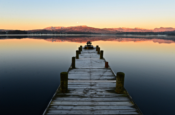 A wooden jetty out over Windermere lake in England's Lake District