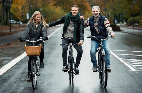  Friends cycling on street in Copenhagen, Denmark.