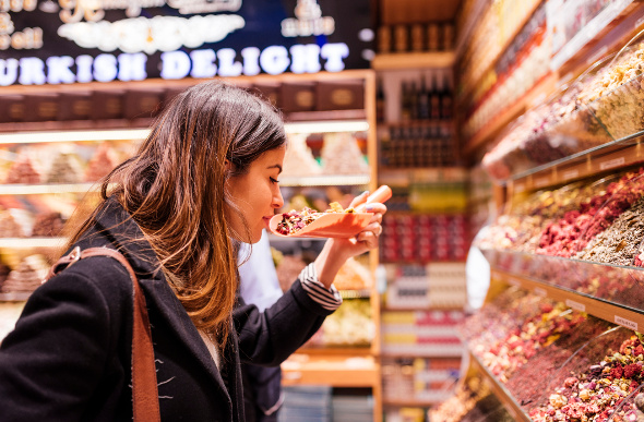 A female traveller smelling sweets in a turkey shop