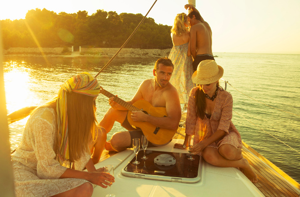 Friends drinking and playing instruments on a yacht in Croatia