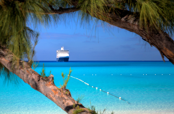 A cruise ship seen from the beach of a tropical island
