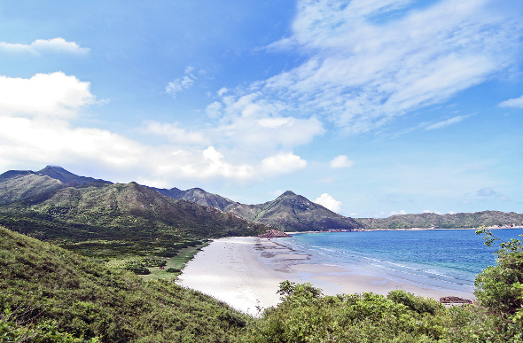 Lush forest meets white sand and blue water at Tai Long Wan beach