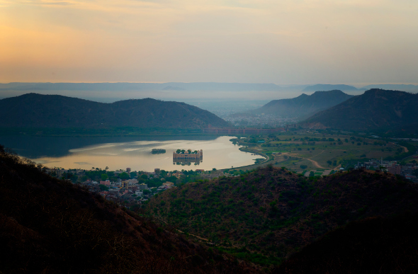 A rural India scene with a palace in the middle of a lake