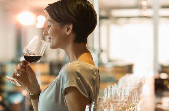 A woman smelling a glass of wine