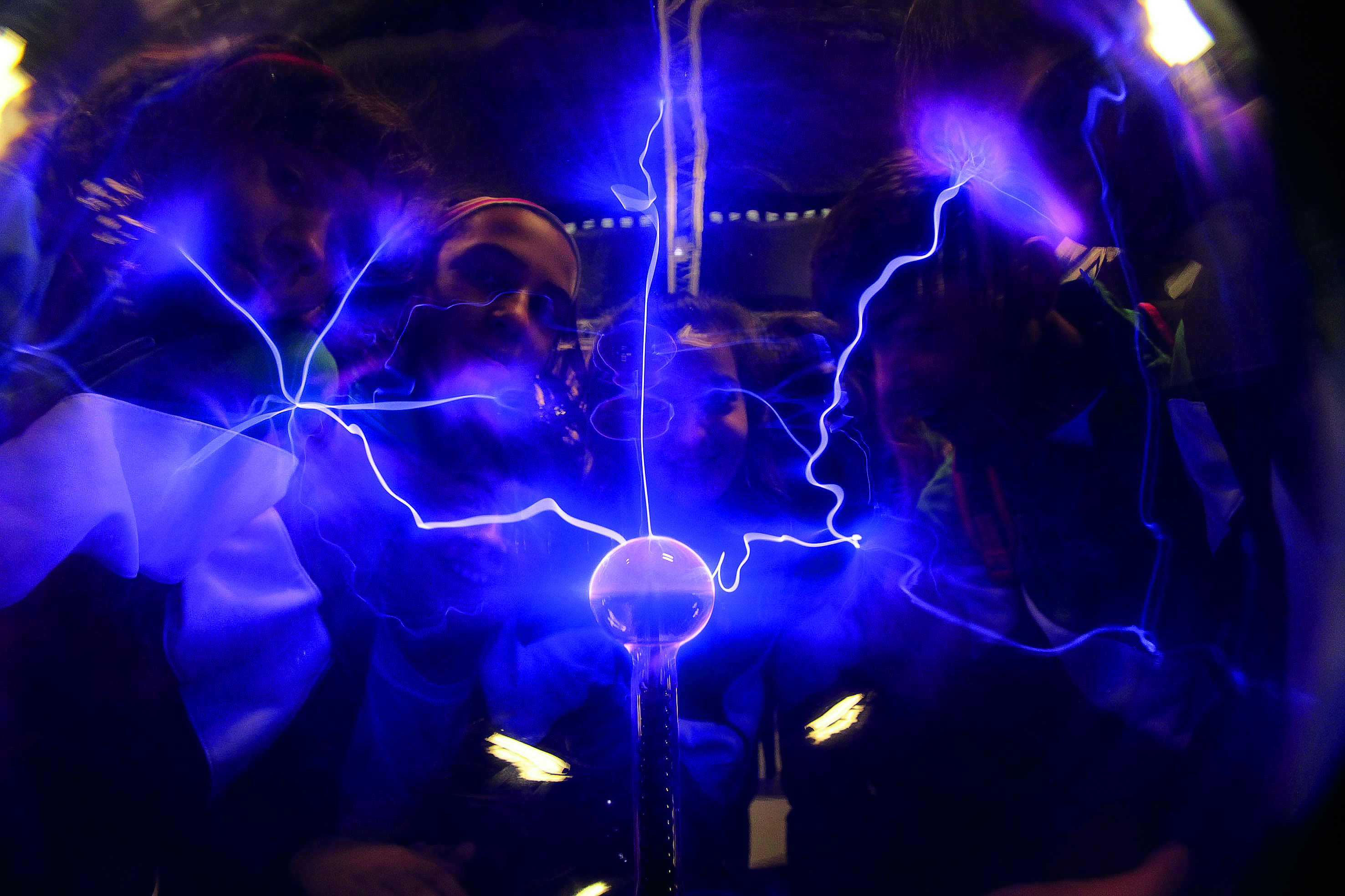A glowing globe sparks with electricity as children look on at the Principe Felipe Science Museum in Spain.
