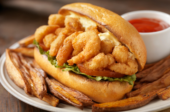 A shrimp Po Boy looks mouthwatering on a plate.
