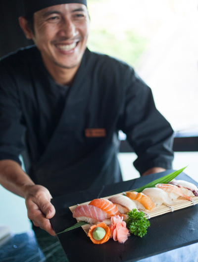 A chef holds a dish of prepared sushi at Nala Rah at Outrigger Konotta Maldives Resort