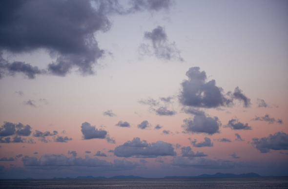 A peach-coloured sky and fluffy clouds viewed from the Reefworld pontoon in the Whitsundays.