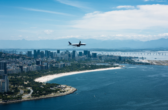 Plane flying over coastal city