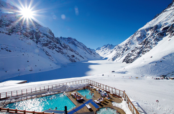 People lounge in a swimming pool beside a frozen lake in Portillo, Chile.