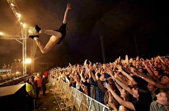 Performer diving off the stage into crowd of people