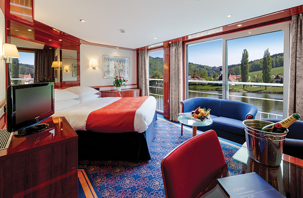 A luxurious river cruise suite with balcony and large bed