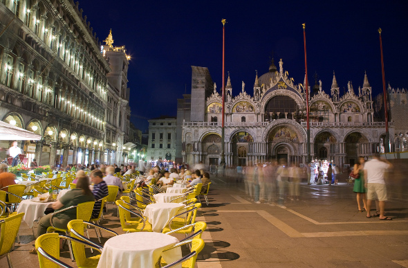People eating and walking in St Mark's Square at night