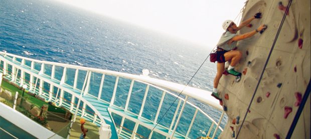 A man climbing a rock-climbing wall on a cruise ship