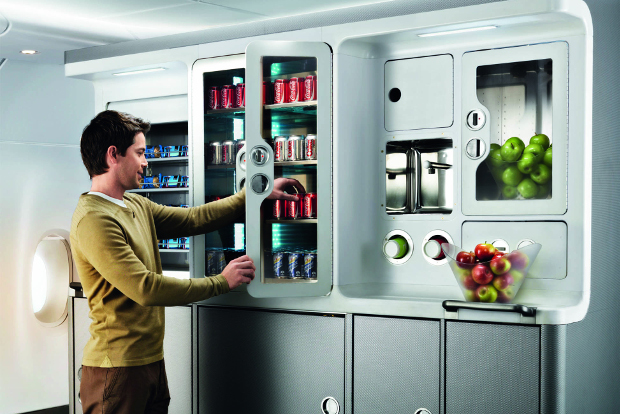 A man taking a Coke from the fridge of the A380 lounge