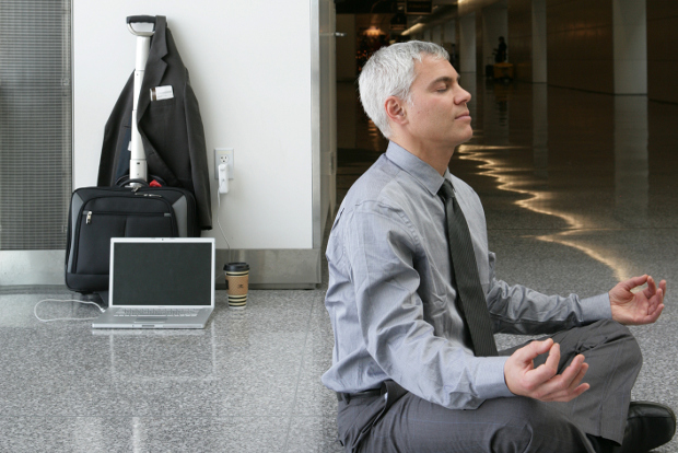 A man doing a yoga pose in the terminal of an airport