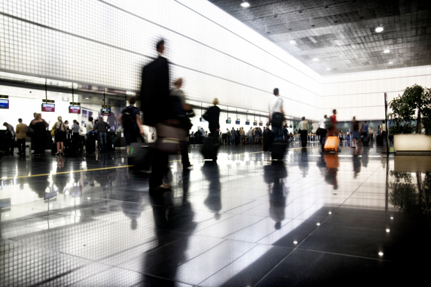 A busy airport terminal with passengers rushing past