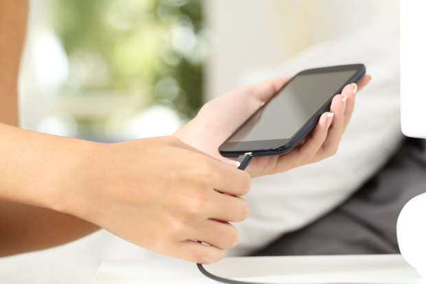 A woman charges her phone.