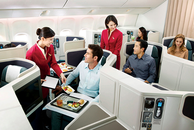 Flight attendants serving meals to business class passengers