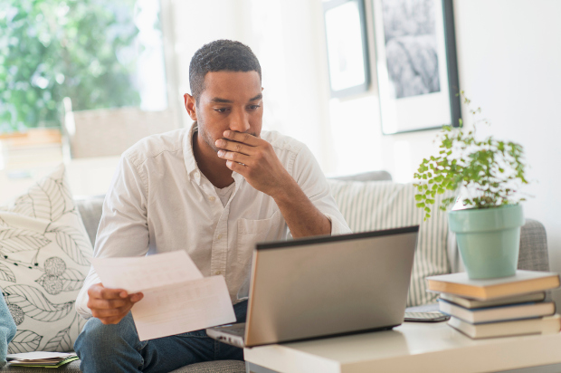 Male paying bills on laptop at home