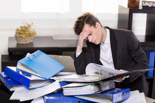 Stressed office worker with files