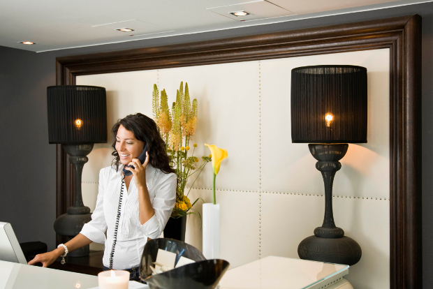 A hotel concierge talking on the phone