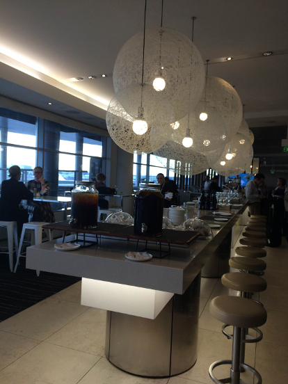 Looking down a long buffet table with people in the background in the Qantas Business Lounge