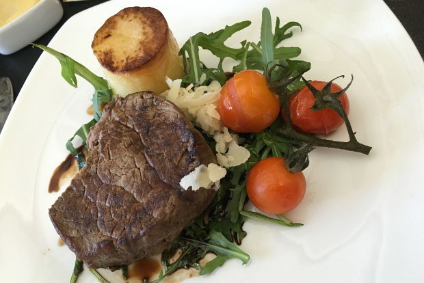 A steak dinner with tomatoes and potatoes